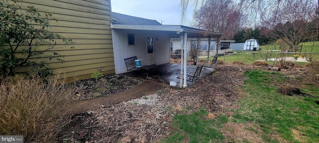 view of yard with a patio area, fence, and a carport