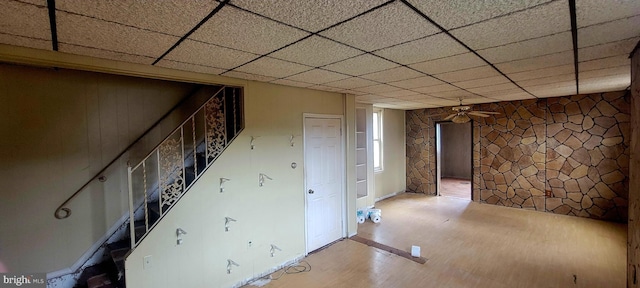 below grade area with wood finished floors and ceiling fan