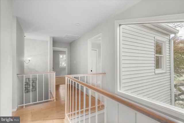 hallway featuring an upstairs landing, wood finished floors, and baseboards