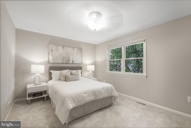 bedroom featuring light colored carpet and baseboards