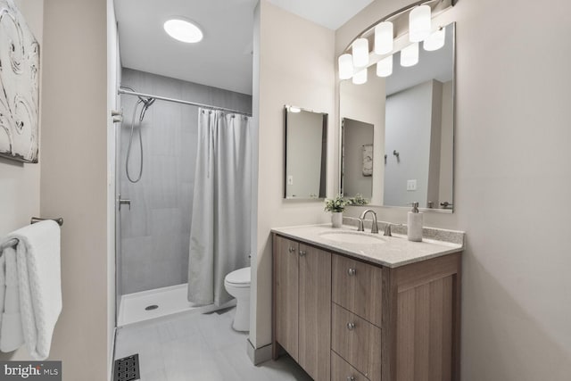 bathroom featuring toilet, a tile shower, vanity, and marble look tiles