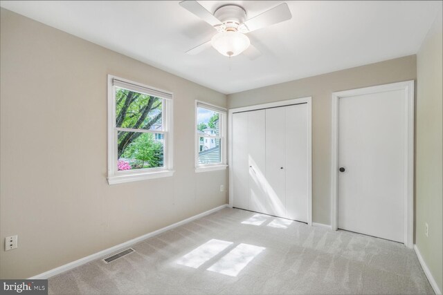 unfurnished bedroom with carpet floors, baseboards, a closet, and a ceiling fan