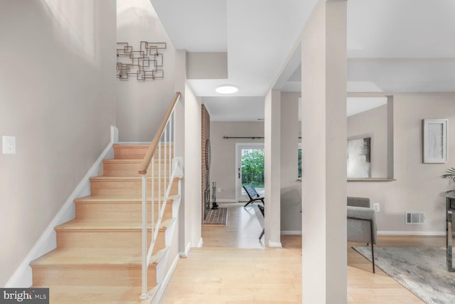 stairs featuring wood finished floors and baseboards