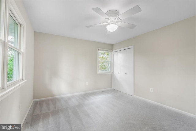 empty room featuring baseboards, carpet, and a ceiling fan