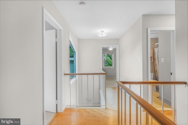 hallway featuring an upstairs landing and light wood finished floors