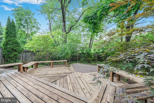 wooden terrace with a fenced backyard