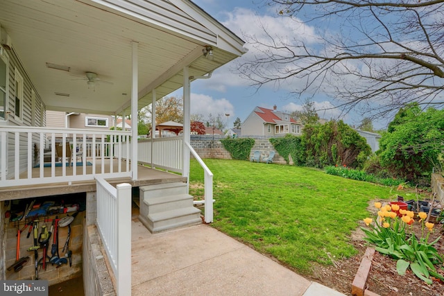 view of yard featuring ceiling fan and fence