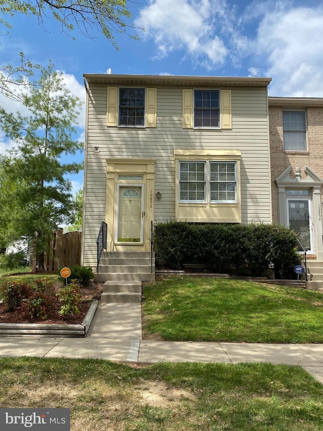 view of front of home with a front lawn, fence, and entry steps