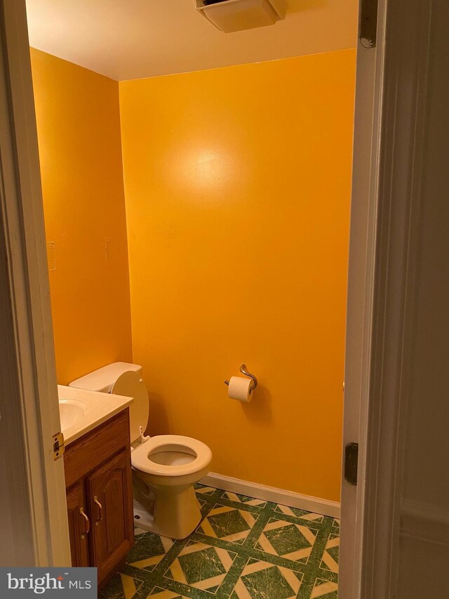 12896 Schalk Ct, Woodbridge, VA 22192 - half bathroom featuring vanity, toilet, and baseboards