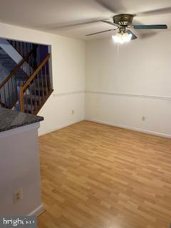 12896 Schalk Ct, Woodbridge, VA 22192 - empty room featuring wood finished floors, a ceiling fan, baseboards, and stairway