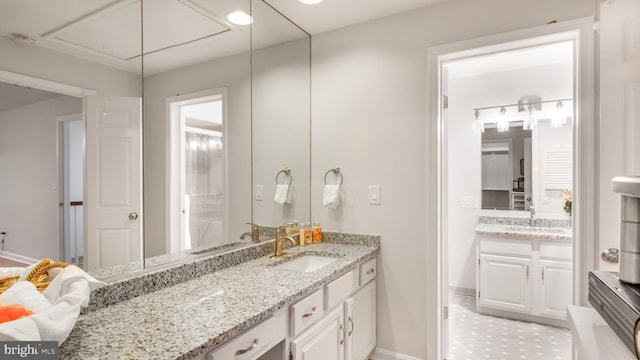 bathroom featuring baseboards and two vanities