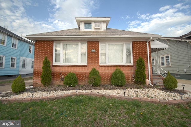 bungalow-style house featuring brick siding and roof with shingles