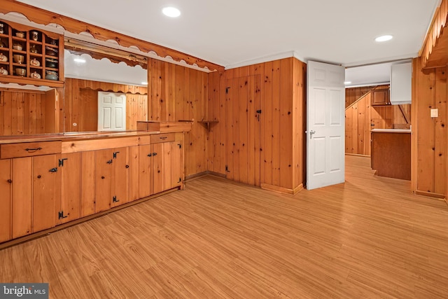 empty room with light wood finished floors, wooden walls, and recessed lighting