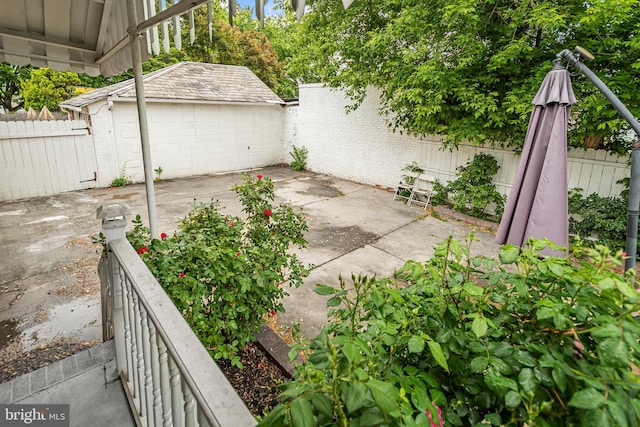 fenced backyard with a patio area and an outdoor structure