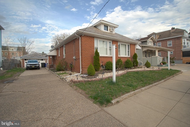 view of front facade featuring brick siding, a front yard, asphalt driveway, and a garage
