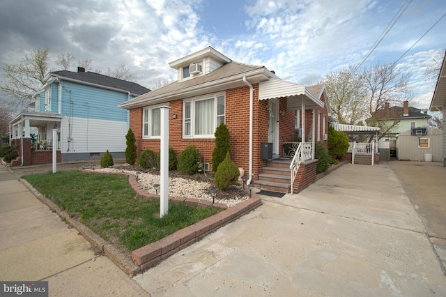bungalow-style home with brick siding and concrete driveway