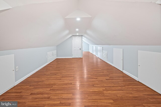 bonus room featuring vaulted ceiling, wood finished floors, and baseboards