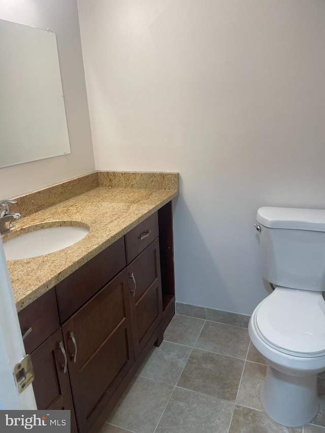 half bathroom featuring vanity, baseboards, and toilet