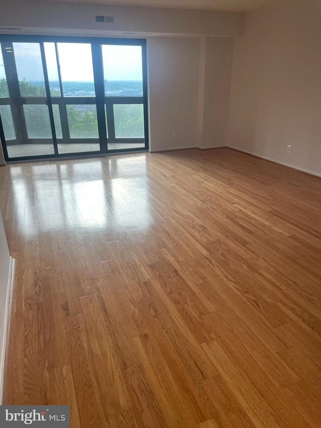 unfurnished room featuring wood finished floors and visible vents