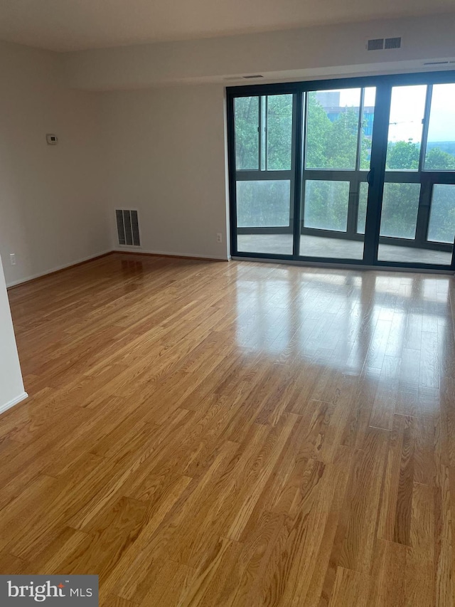 spare room featuring visible vents, plenty of natural light, and light wood finished floors