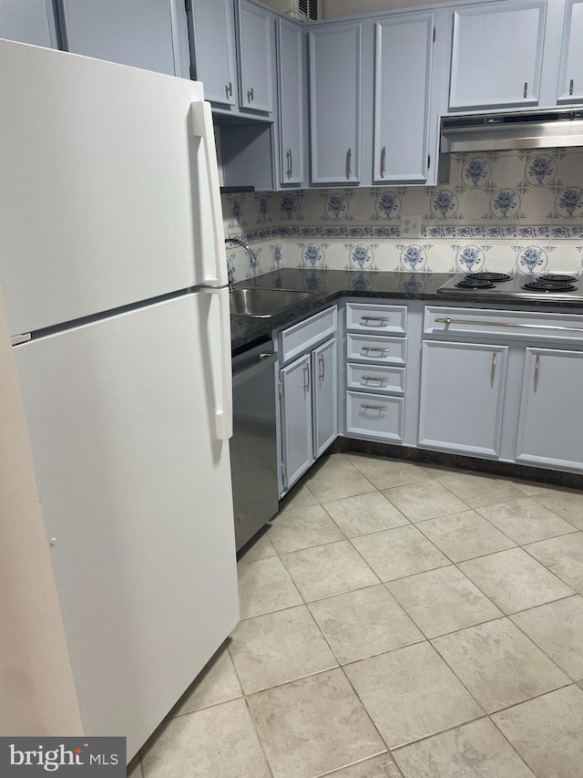 kitchen with dark countertops, dishwasher, a sink, freestanding refrigerator, and under cabinet range hood