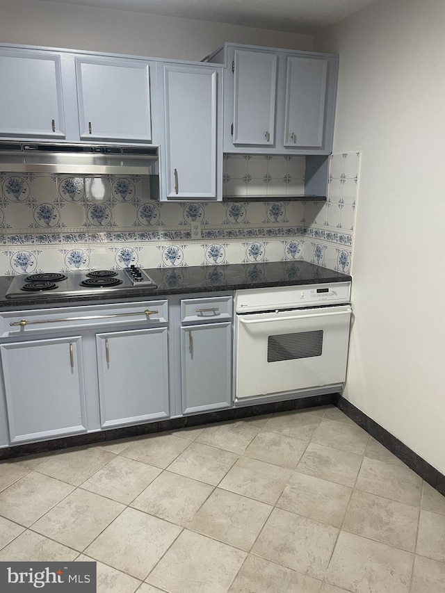kitchen featuring stainless steel electric cooktop, tasteful backsplash, under cabinet range hood, and white oven