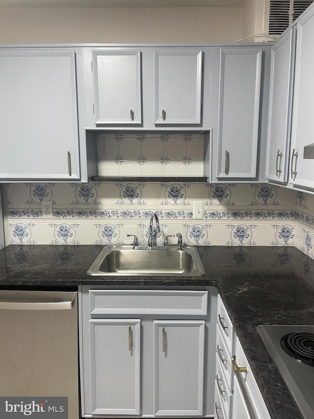kitchen with a sink, white cabinetry, tasteful backsplash, and stainless steel appliances