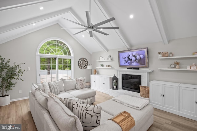 living area with light wood-style flooring, lofted ceiling with beams, and ceiling fan