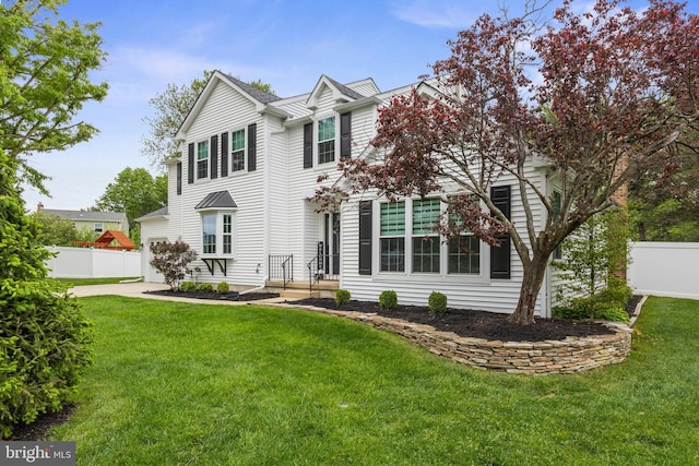 view of front of property with fence and a front lawn