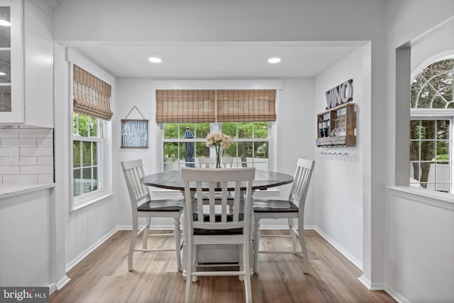 dining area with light wood finished floors, baseboards, and recessed lighting