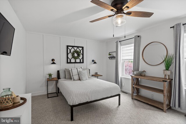 bedroom featuring light colored carpet, visible vents, baseboards, and ceiling fan