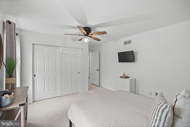 carpeted bedroom with a ceiling fan, baseboards, a closet, and visible vents