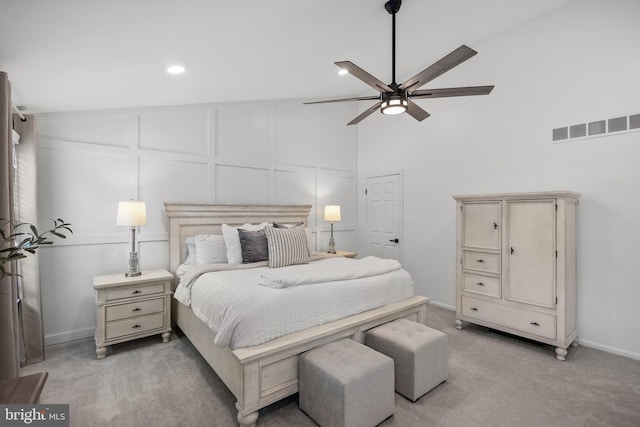 bedroom with visible vents, a decorative wall, baseboards, light carpet, and recessed lighting