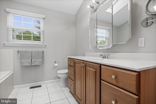 full bath featuring baseboards, tile patterned flooring, vanity, tiled bath, and toilet