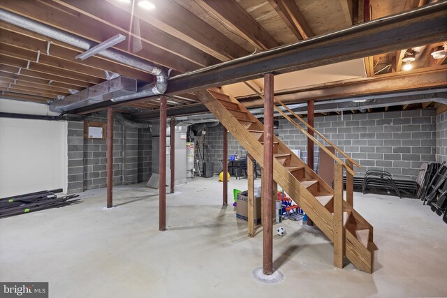 unfinished below grade area featuring stairway and concrete block wall