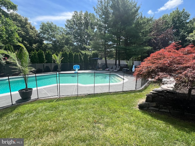 view of pool featuring a yard, a patio area, a fenced in pool, and fence