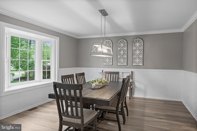 dining area with visible vents, wood finished floors, and ornamental molding