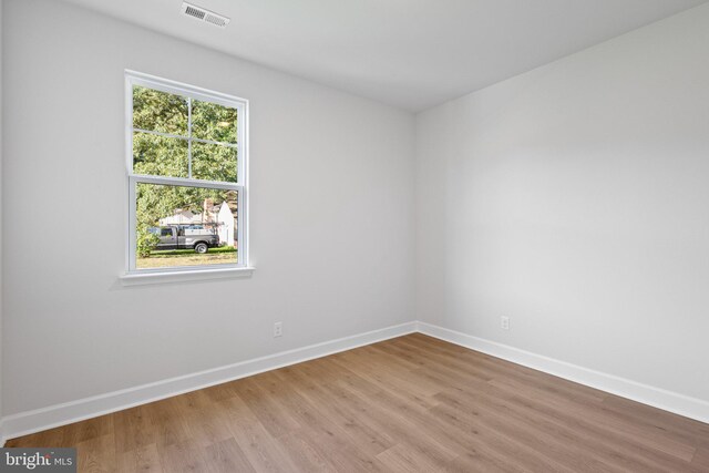 unfurnished room featuring baseboards, visible vents, and light wood-type flooring
