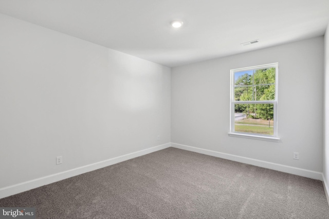spare room featuring visible vents, baseboards, and carpet floors