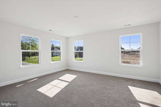 carpeted spare room featuring baseboards and visible vents