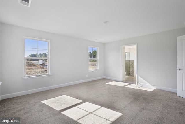 unfurnished bedroom with baseboards, carpet flooring, ensuite bath, and visible vents