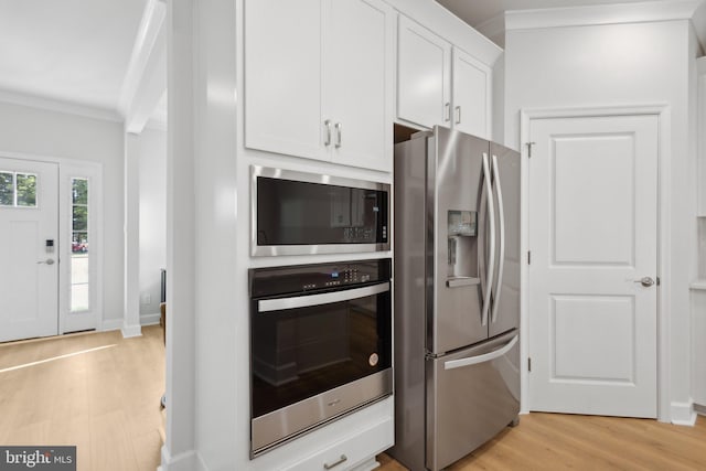 kitchen featuring white cabinets, stainless steel appliances, baseboards, light wood-type flooring, and ornamental molding