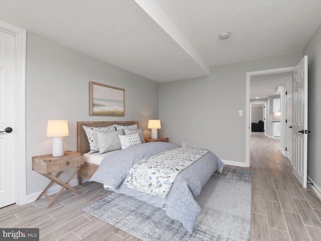 bedroom featuring wood tiled floors and baseboards
