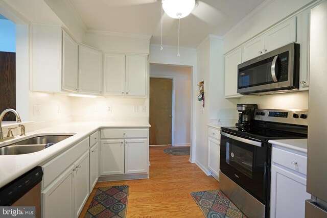 33955 Middleton Cir Unit 5, Lewes, DE 19958 - kitchen with stainless steel appliances, a sink, ceiling fan, white cabinets, and crown molding