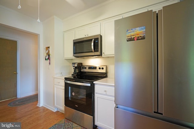 33955 Middleton Cir Unit 5, Lewes, DE 19958 - kitchen featuring stainless steel appliances, crown molding, light countertops, white cabinets, and light wood-style flooring