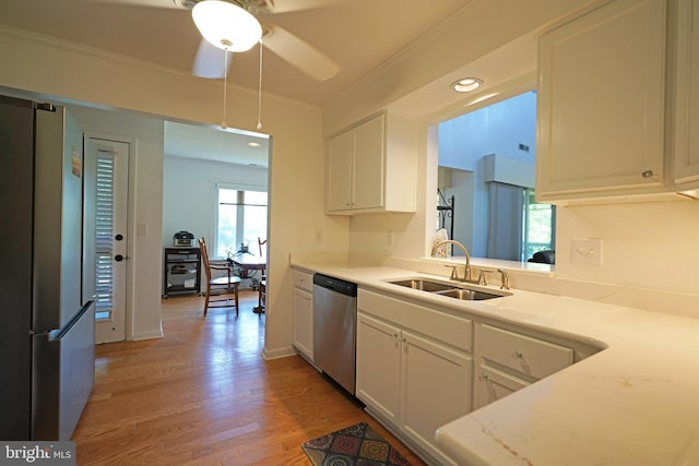 33955 Middleton Cir Unit 5, Lewes, DE 19958 - kitchen featuring stainless steel appliances, a sink, white cabinets, light wood-style floors, and light countertops