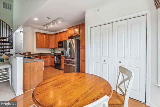 1507 Broadneck Pl Unit 403, Annapolis, MD 21409 - kitchen with black appliances, a peninsula, light wood-style flooring, and a sink