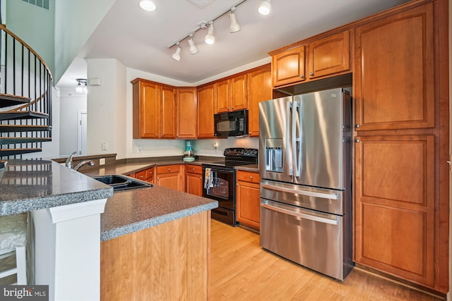1507 Broadneck Pl Unit 403, Annapolis, MD 21409 - kitchen featuring black appliances, a sink, a peninsula, light wood-style floors, and brown cabinetry