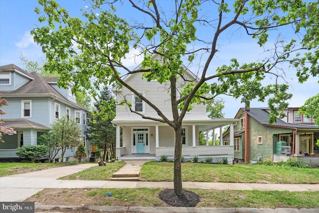 view of front of home featuring covered porch, driveway, and a front lawn