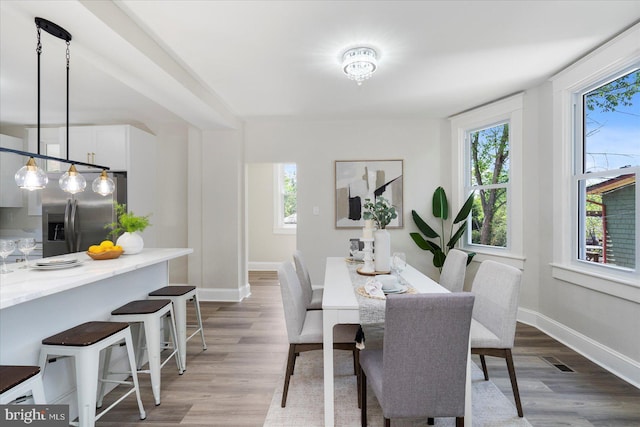 dining area with a healthy amount of sunlight, baseboards, and wood finished floors